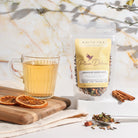 White tea blend with cinnamon and black currant from Plum Deluxe Tea, featuring a resealable tea package with a white and purple design.
