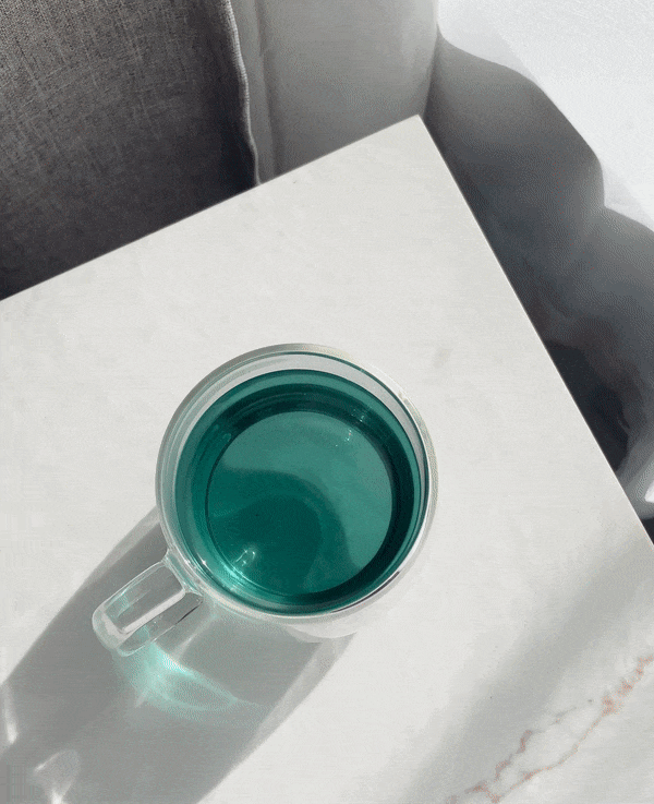 Plum Deluxe Butterfly Effect Green and White Tea with mango and peach flavor, featuring fresh tea leaves and fruit pieces.