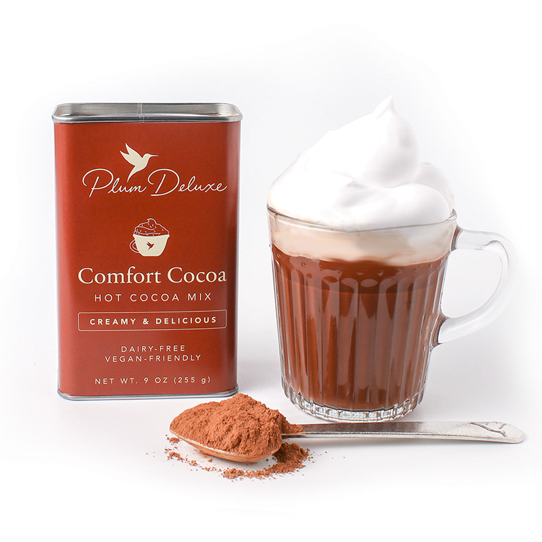 Dairy-free Comfort Cocoa Hot Cocoa Mix by Plum Deluxe Tea, showing the hot cocoa mix in a cozy mug with cocoa powder.