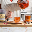 Copper Rose glass teapot with tea warmer by Plum Deluxe Tea, showcasing a stylish, transparent teapot and cozy warmer.