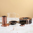 Copper Rose glass teapot with warmer by Plum Deluxe Tea, showcasing elegant glass design and warm tea inside.