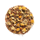 Cuddletime Herbal Tea by Plum Deluxe, featuring chamomile and mint, in a clear tea bag with dried herbs visible.