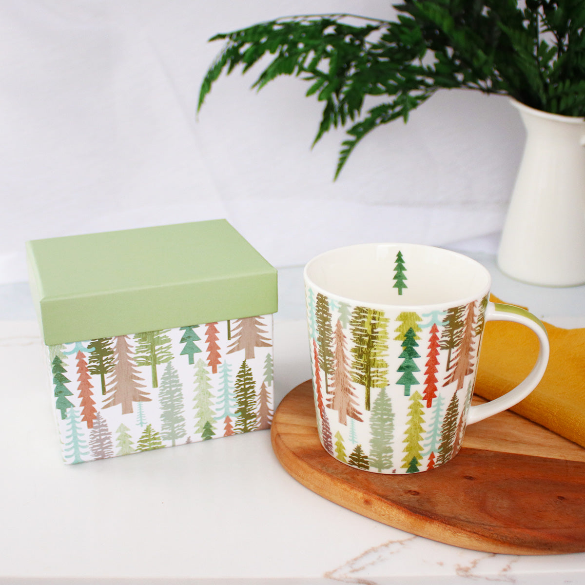 Festive Trees Holiday Mug by Plum Deluxe Tea with a decorative gift box, perfect for seasonal tea moments.