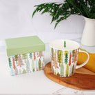 Festive Trees Holiday Mug by Plum Deluxe Tea with a decorative gift box, perfect for seasonal tea moments.