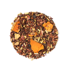 Golden Cacao Herbal Tea by Plum Deluxe, featuring turmeric and chocolate, displayed in a cozy teacup with tea leaves.