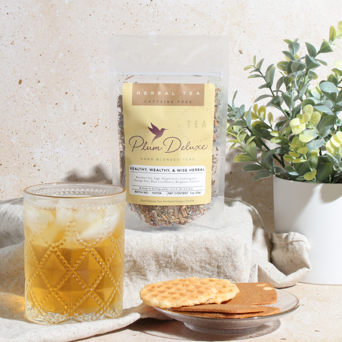 Healthy, Wealthy, & Wise Herbal Tea by Plum Deluxe featuring bergamot, sage, lemongrass, and mint in a tea cup.