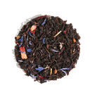 Huckleberry Happiness Black Tea by Plum Deluxe Tea in a clear glass cup with brewed tea and fresh huckleberries.
