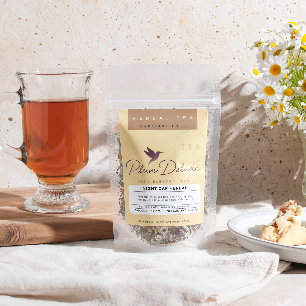 Herbal tea blend in a glass mug with valerian root and peppermint, featuring Plum Deluxe Tea Night Cap Herbal Tea.