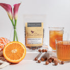 Oregon Breakfast Black Tea with Hazelnut and Orange flavor by Plum Deluxe Tea, displayed in a clear tea cup with tea leaves.