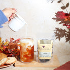Cup of Plum Deluxe Pumpkin Spice Brulee Oolong Tea in a clear glass mug, showcasing the warm, spiced tea with a hint of caramel color.