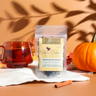 Cup of Pumpkin Spice Brulee Oolong Tea by Plum Deluxe Tea, showcasing a steaming brewed tea in a clear glass cup.