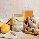 Herbal tea blend with ginger and lemon in a glass cup, featuring fresh lemon slices and ginger root for rejuvenation.