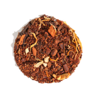 Spicy Caramel Apple Cinnamon herbal tea in a tea bag, with caramel pieces and cinnamon sticks visible for Plum Deluxe Tea.