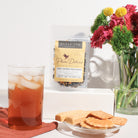 Sweet Georgia Peach Black Tea by Plum Deluxe with hints of caramel and walnut, showcasing the tea leaves and flavor infusions.