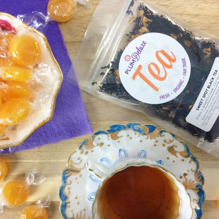 A cup of Sweet Spot Black Tea with butterscotch flavor from Plum Deluxe Tea, showing a steaming black tea in a white teacup.