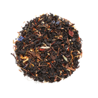 Plum Deluxe Tea Toasted Nut Brulee Oolong Tea in a clear glass cup with brewed tea and loose leaves on a wooden surface.
