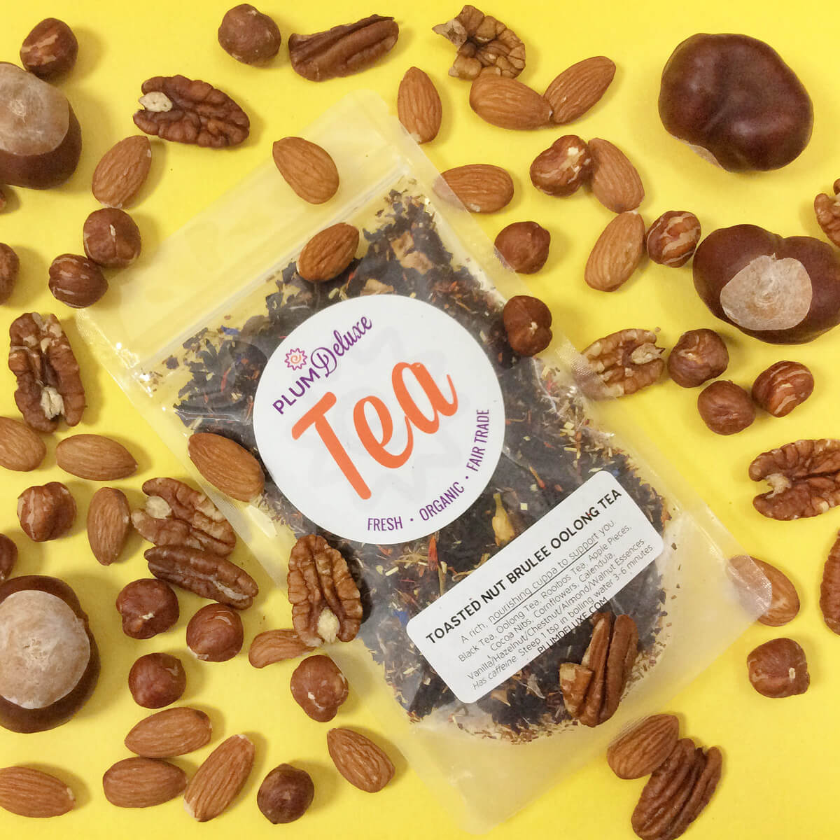 Plum Deluxe Toasted Nut Brulee Oolong Tea in a glass teacup showing its rich amber color and aromatic steam.