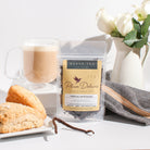 Vanilla Latte Tea by Plum Deluxe featuring a warm blend of cardamom and vanilla creme in a tea cup on a cozy table setting.