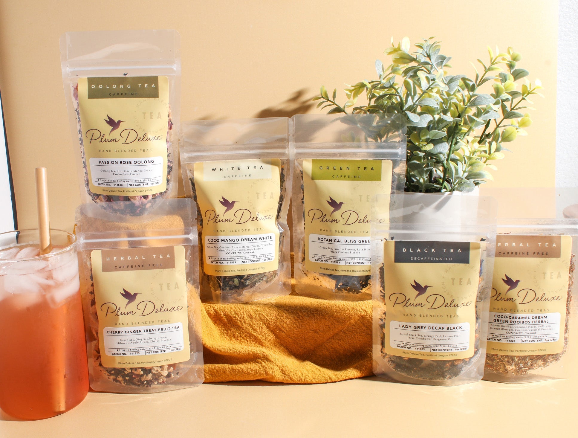 Assorted tea tins from Plum Deluxe Tea's World of Tea Summer Vacation Bundle, featuring vibrant packaging and tea varieties.