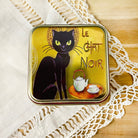 Le Chat Noir tea tin by Plum Deluxe Tea featuring a vintage-style black cat design on a metal storage container.