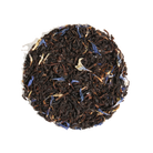 Cup of Plum Deluxe Tea's Mindful Morning Tea Blend Earl Grey with bergamot and tea leaves in a cozy setting.