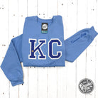 Powder blue KC glitter applique crewneck sweatshirt from The Graphic Tee featuring a casual, stylish design with glitter accents.