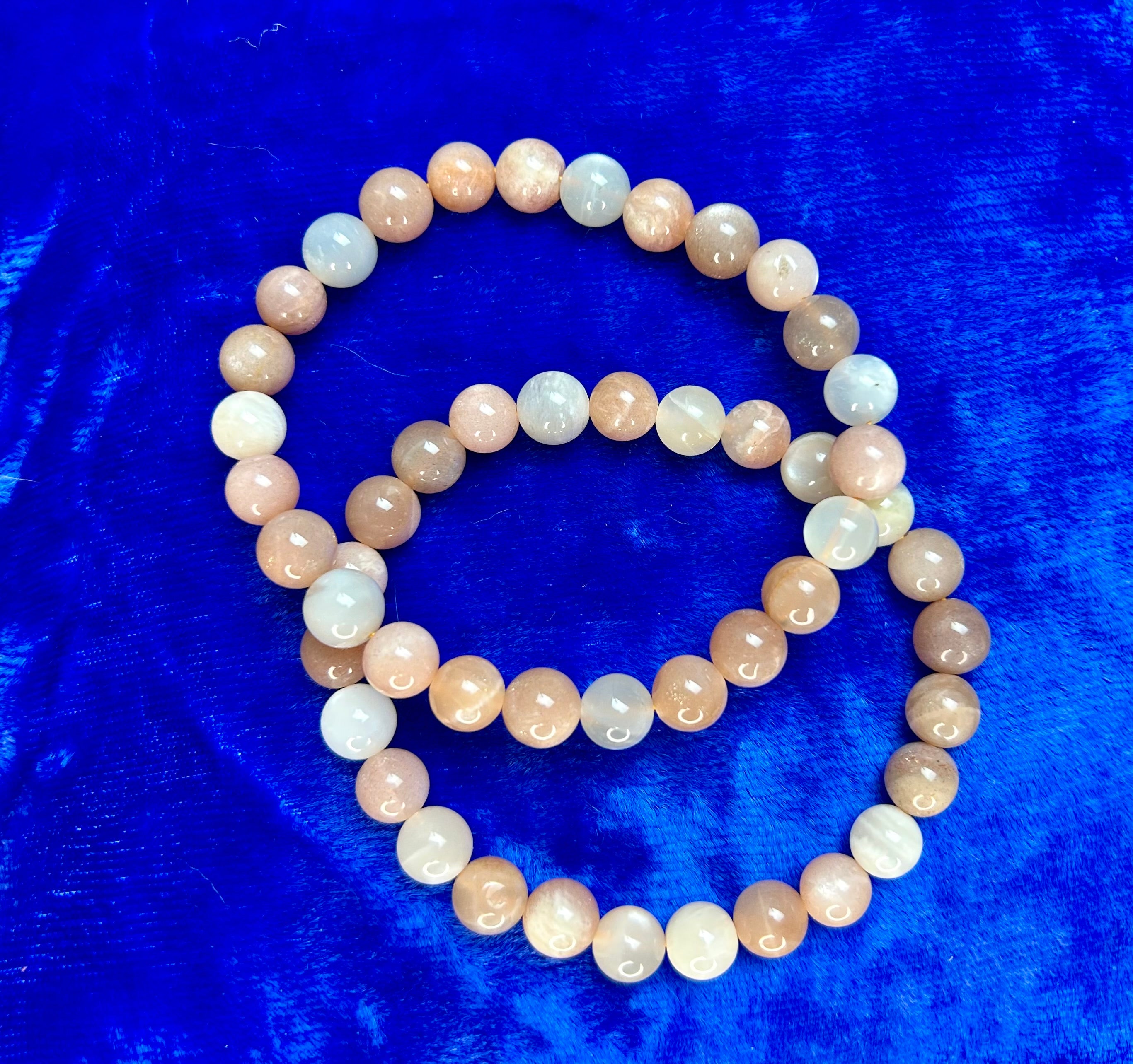 Mixed moonstone bracelet with 8 mm beads from Practical Magic Store, featuring smooth, iridescent stones on a flexible bracelet.