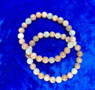 Mixed moonstone bracelet with 8 mm beads from Practical Magic Store, featuring smooth, iridescent stones on a flexible bracelet.