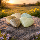 Green pistachio calcite hearts gemstone healing crystals from Practical Magic Store on a white background.
