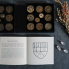 Set of 20 Prisma Visions geomancy coins with intricate symbols, used for divination and spiritual practices.