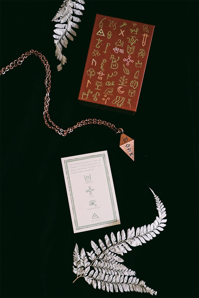 Green Glyphs Pendulum by Prisma Visions showing a detailed, ornamental pendulum with intricate green glyph designs.