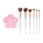 Set of seven Profusion Cosmetics Frosted Snow Sparkle makeup brushes with cleaning mat, featuring elegant handles and soft bristles.