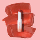 Profusion Cosmetics Glimmer Balm hydrating melting lip balm in coral shade, moisturizing lips with a shimmering finish.