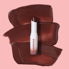 Profusion Cosmetics Glimmer Balm Hydrating Melting Lip Balm in coral, showing smooth, glossy lips with a shimmering finish.