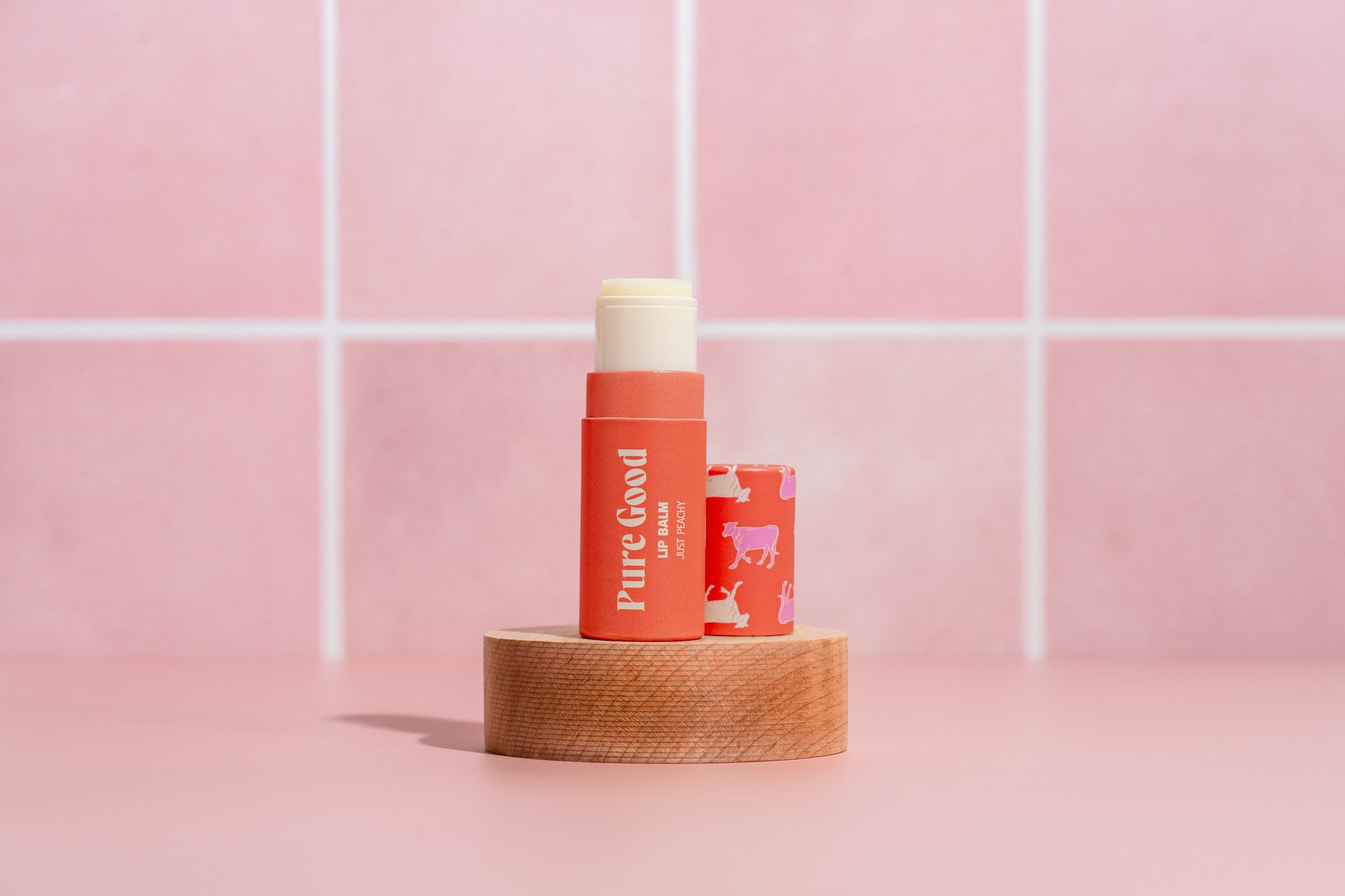 Pure Good LLC citrus tallow lip balm showing a small jar with orange-tinted balm and natural packaging.