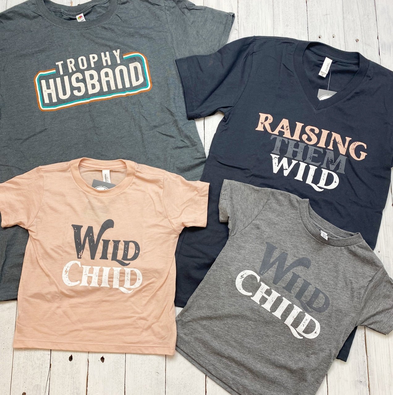 Raising Them Wild V-Neck SS Graphic Tee by The Graphic Tee, featuring a stylish V-neck design and wild-themed graphic print.