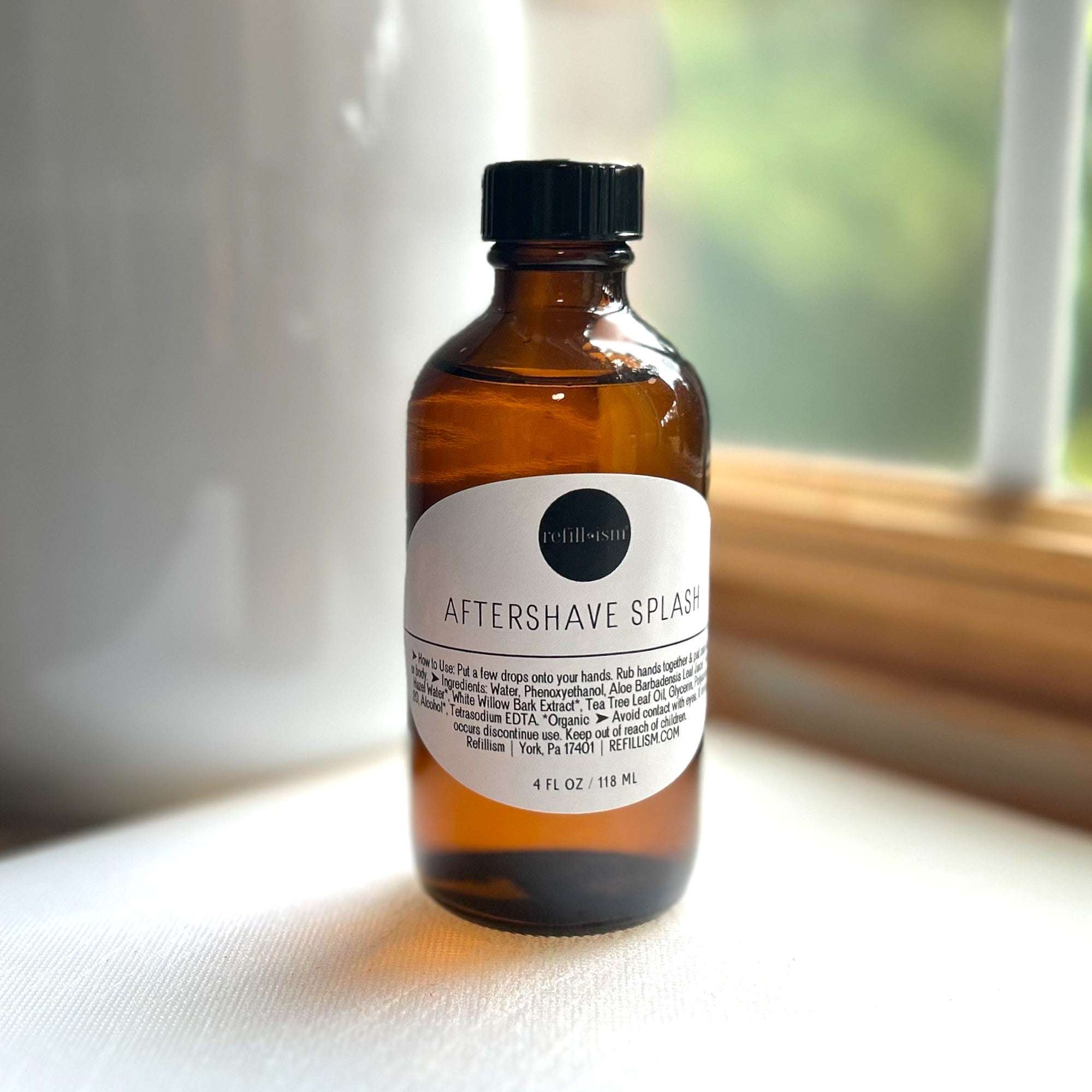 Reformism 4oz aftershave splash in a clear glass bottle, designed for soothing and refreshing men's personal care.