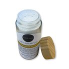 Refillism dry shampoo in lemongrass and verbena scent, in a glass shaker bottle, for fresh and clean hair care.