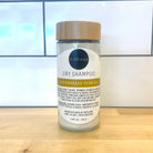 Refillism dry shampoo with lemongrass and verbena in a glass shaker for natural personal care.