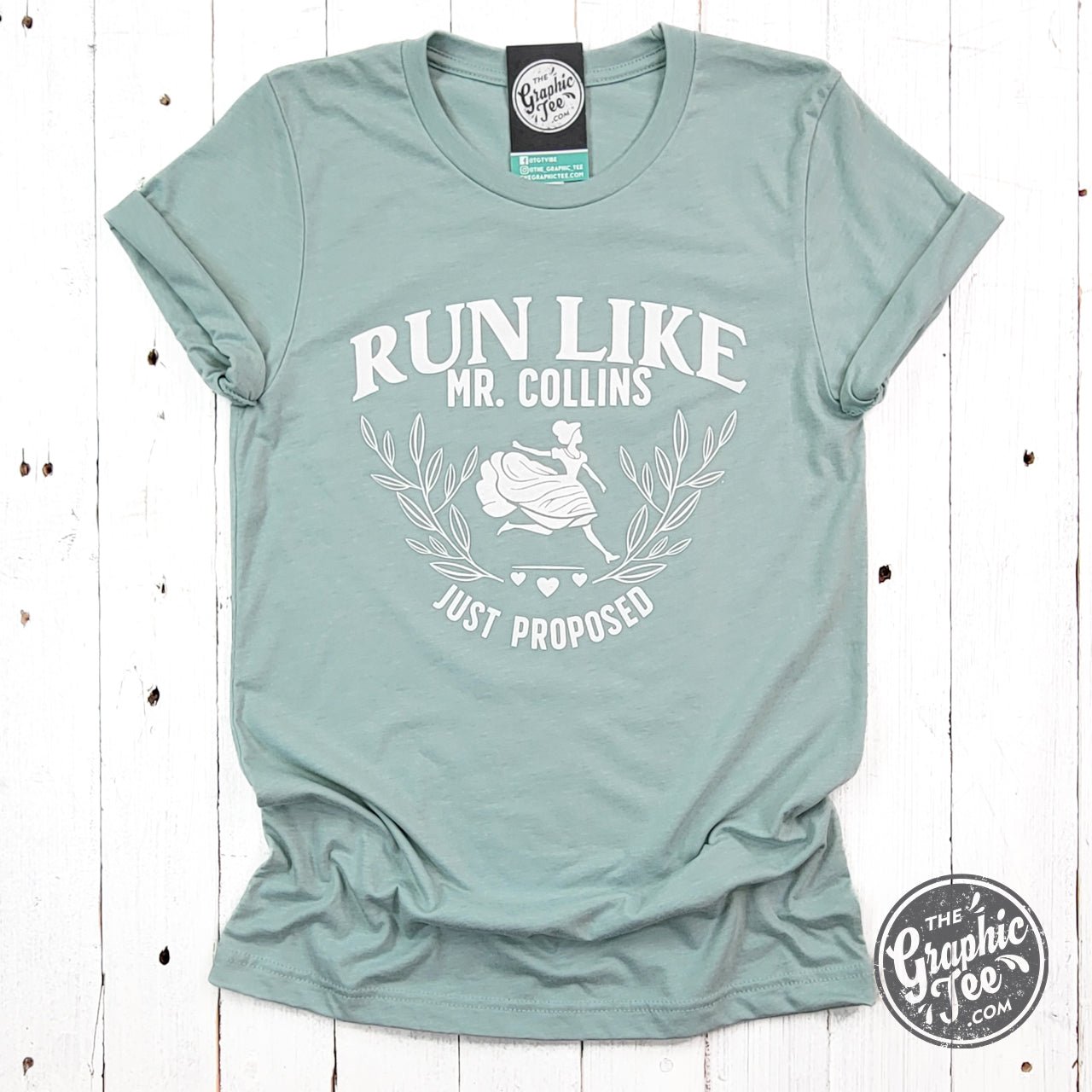 Bright graphic short sleeve tee by The Graphic Tee featuring "Run Like Mr. Collins Just Proposed" design on soft fabric.