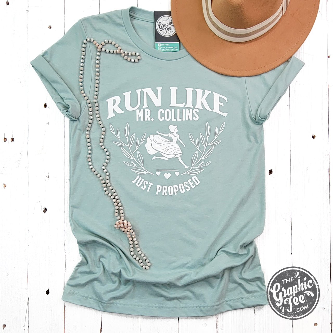 Short sleeve graphic tee by The Graphic Tee featuring "Run Like Mr. Collins Just Proposed" design on a casual men's t-shirt.