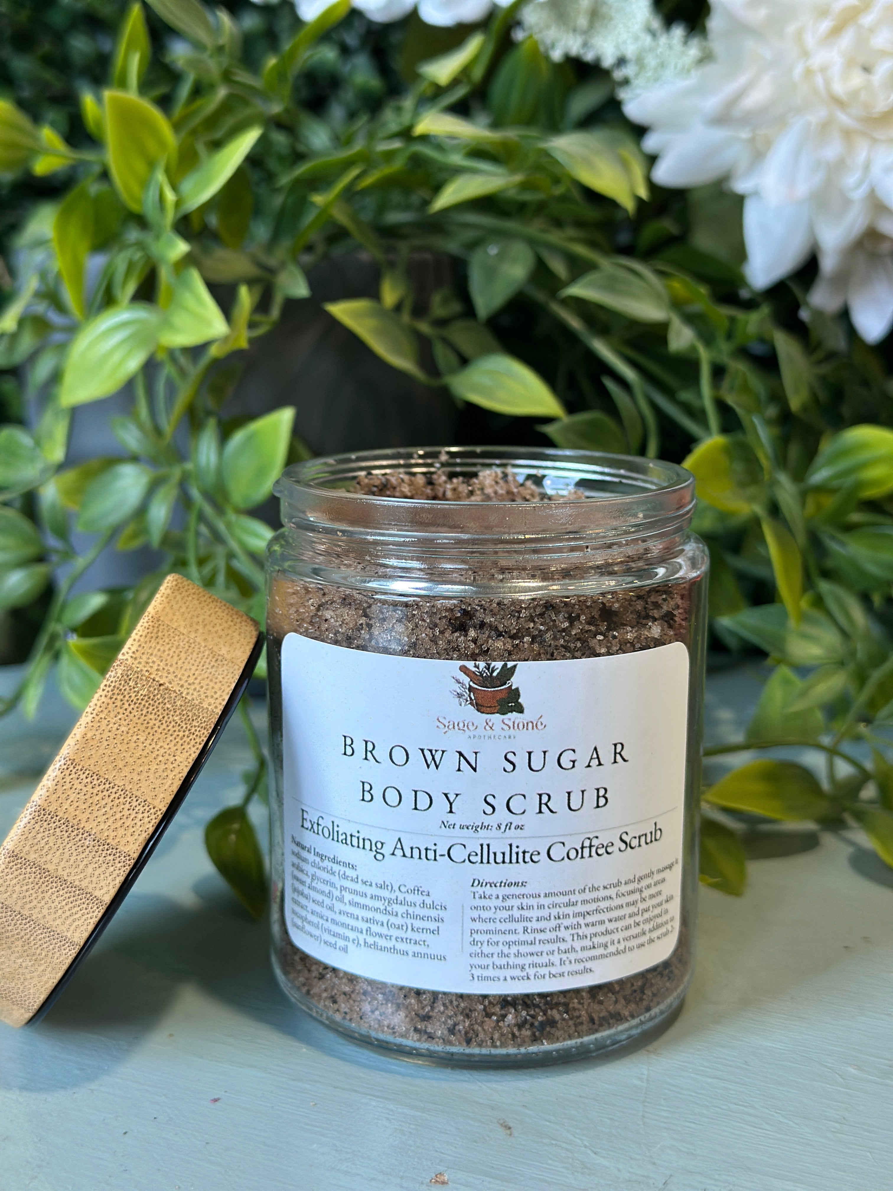 Sage & Stone Apothecary exfoliating anti-cellulite coffee scrub in a jar, showing textured coffee grounds and natural ingredients.