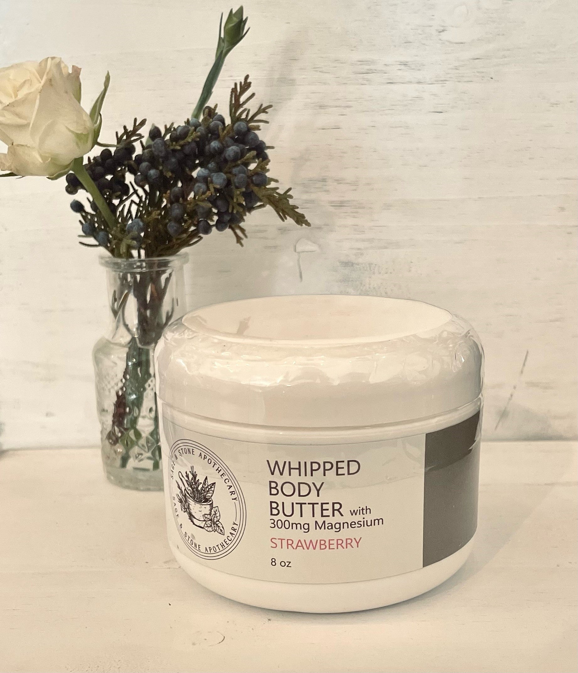 Whipped strawberry magnesium body butter by Sage & Stone Apothecary, showcasing a smooth, pink creamy moisturizer in a jar.