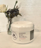 Whipped strawberry magnesium body butter by Sage & Stone Apothecary, showcasing a smooth, pink creamy moisturizer in a jar.