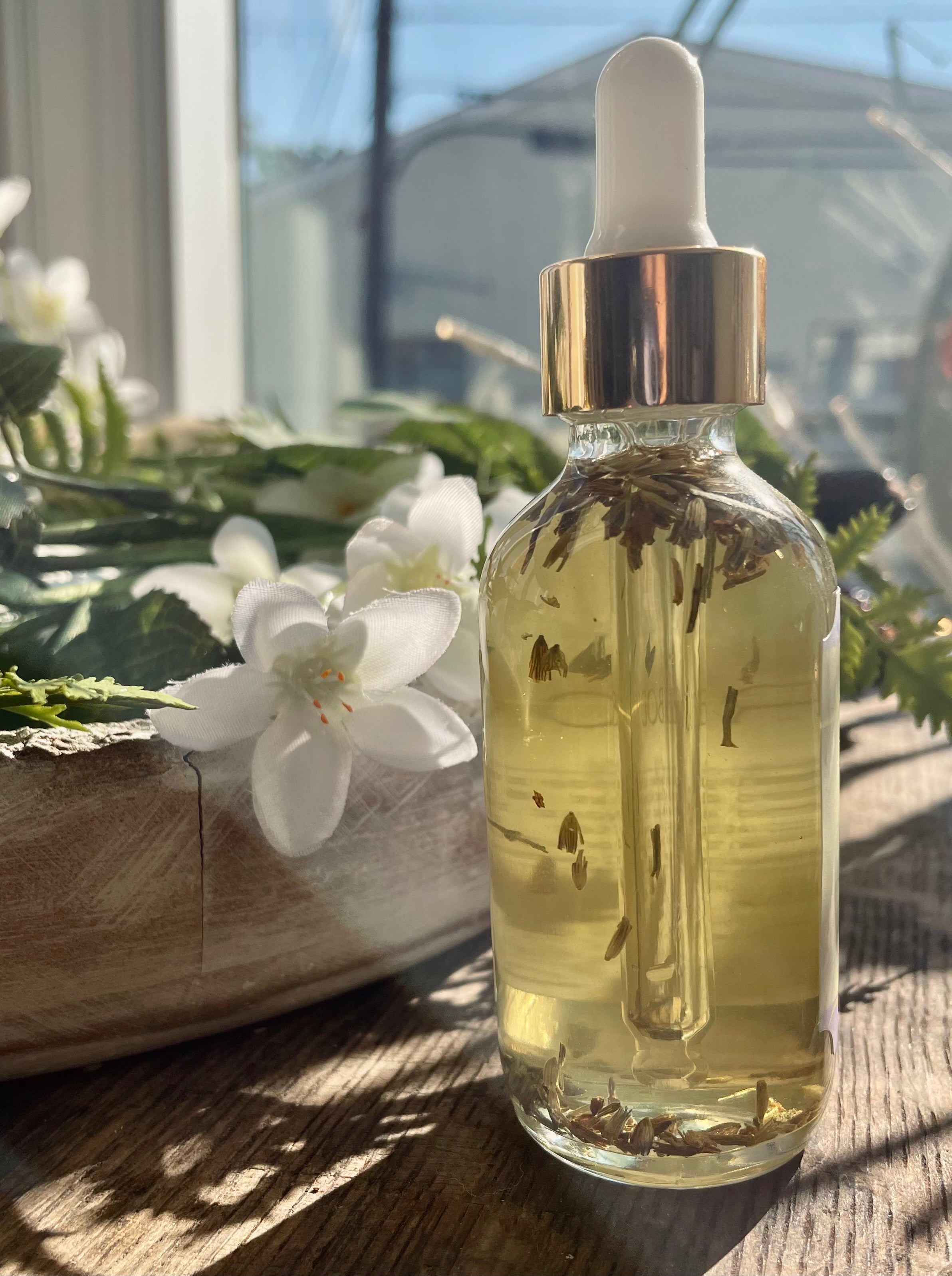 Lavender body oil in a glass bottle from Sage & Stone Apothecary, with fresh lavender sprigs and a relaxing spa setting.