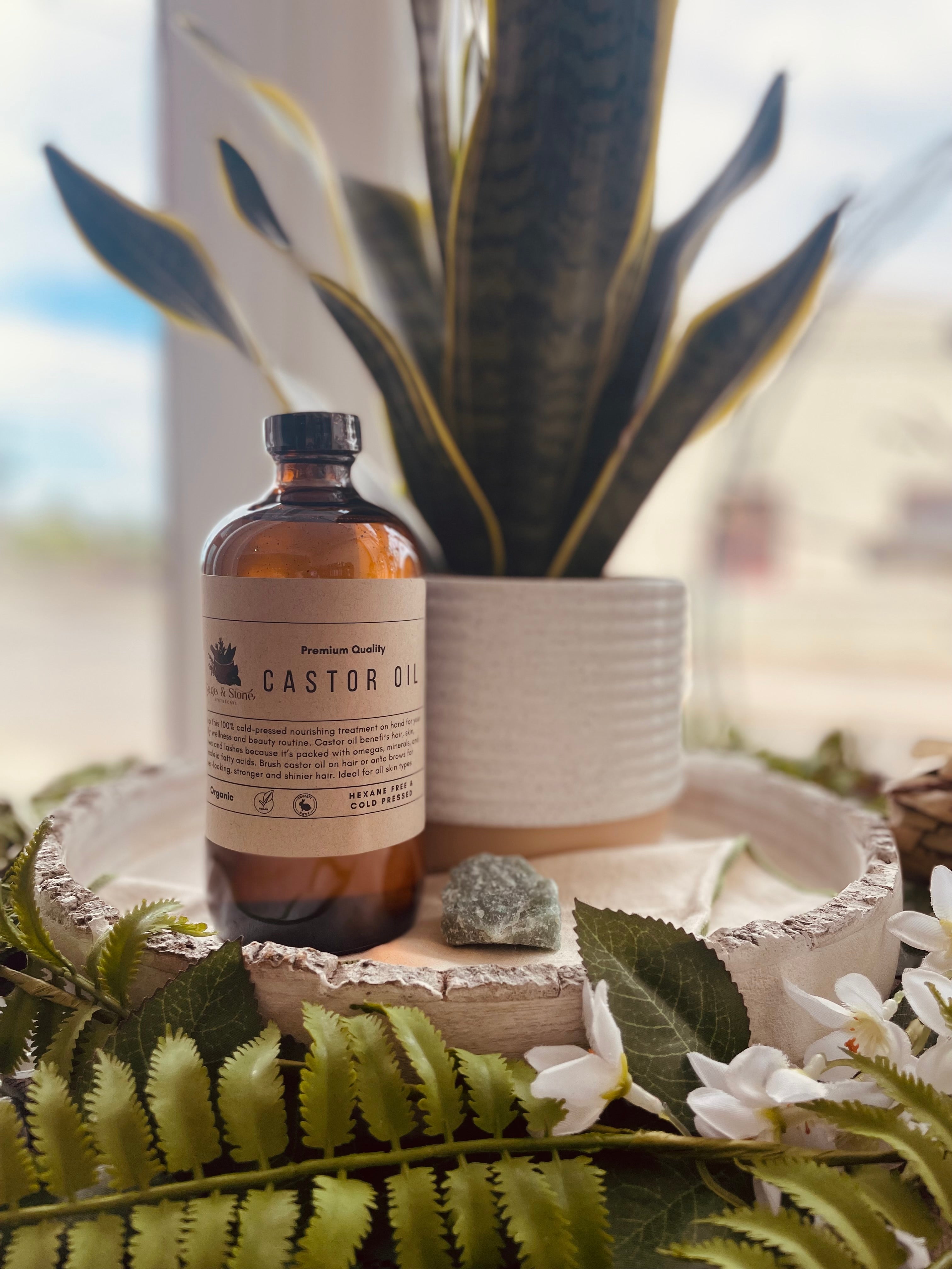 Bottle of Sage & Stone Apothecary organic cold pressed castor oil for body care and wellness, with a clear label on a white background.