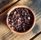 Rose Hip Facial Serum from Sage & Stone Apothecary, natural body care product with a glass dropper bottle and fresh rose hips.