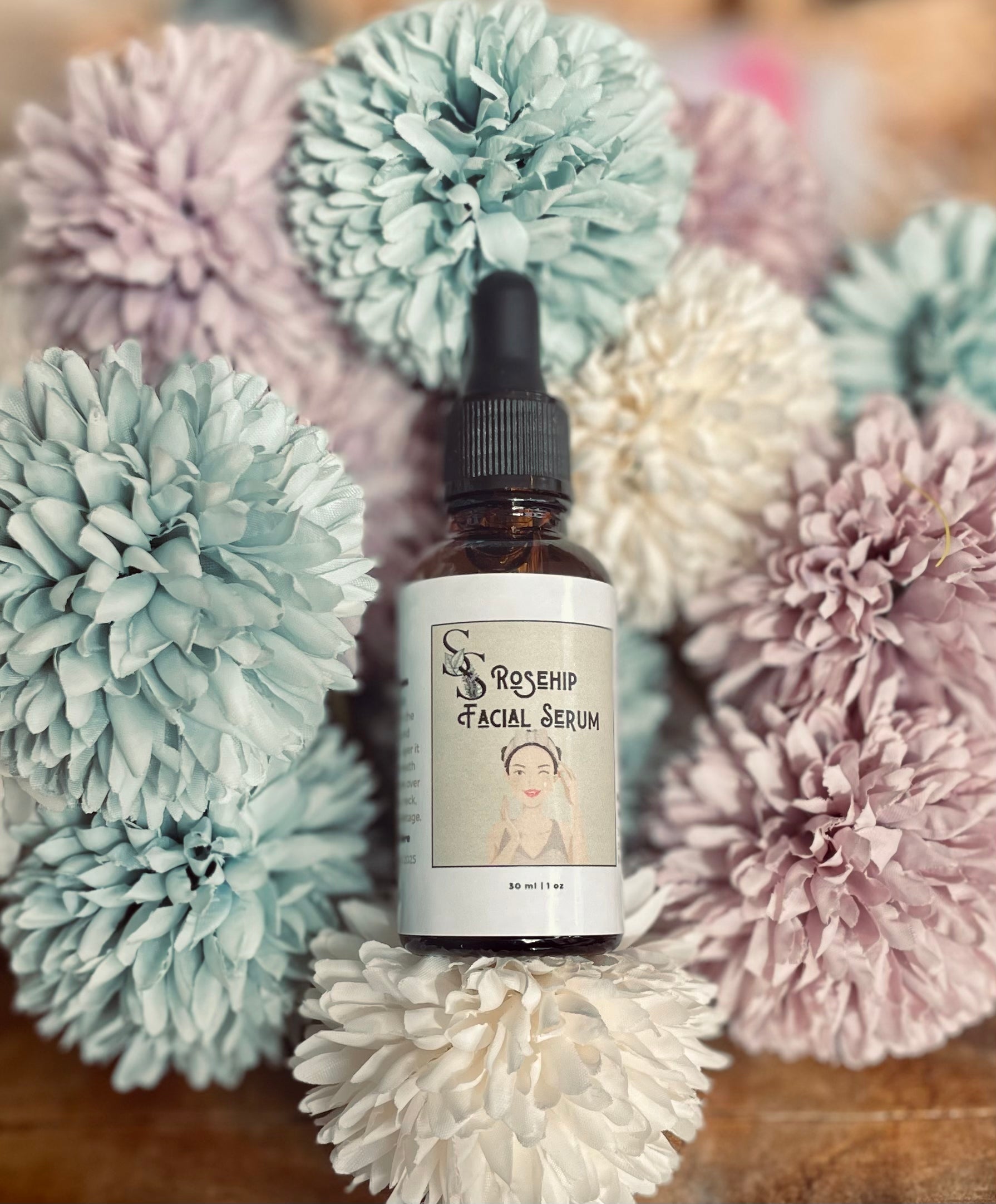 Rose Hip Facial Serum from Sage & Stone Apothecary, featuring a glass bottle with dropper, surrounded by rose hips and botanical elements.