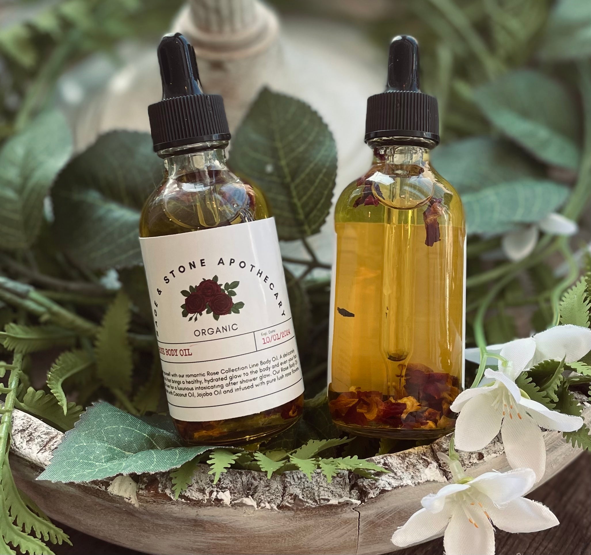 Sage & Stone Apothecary rose body oil bottle with a pump dispenser, featuring a clear glass container and a rose-themed label.