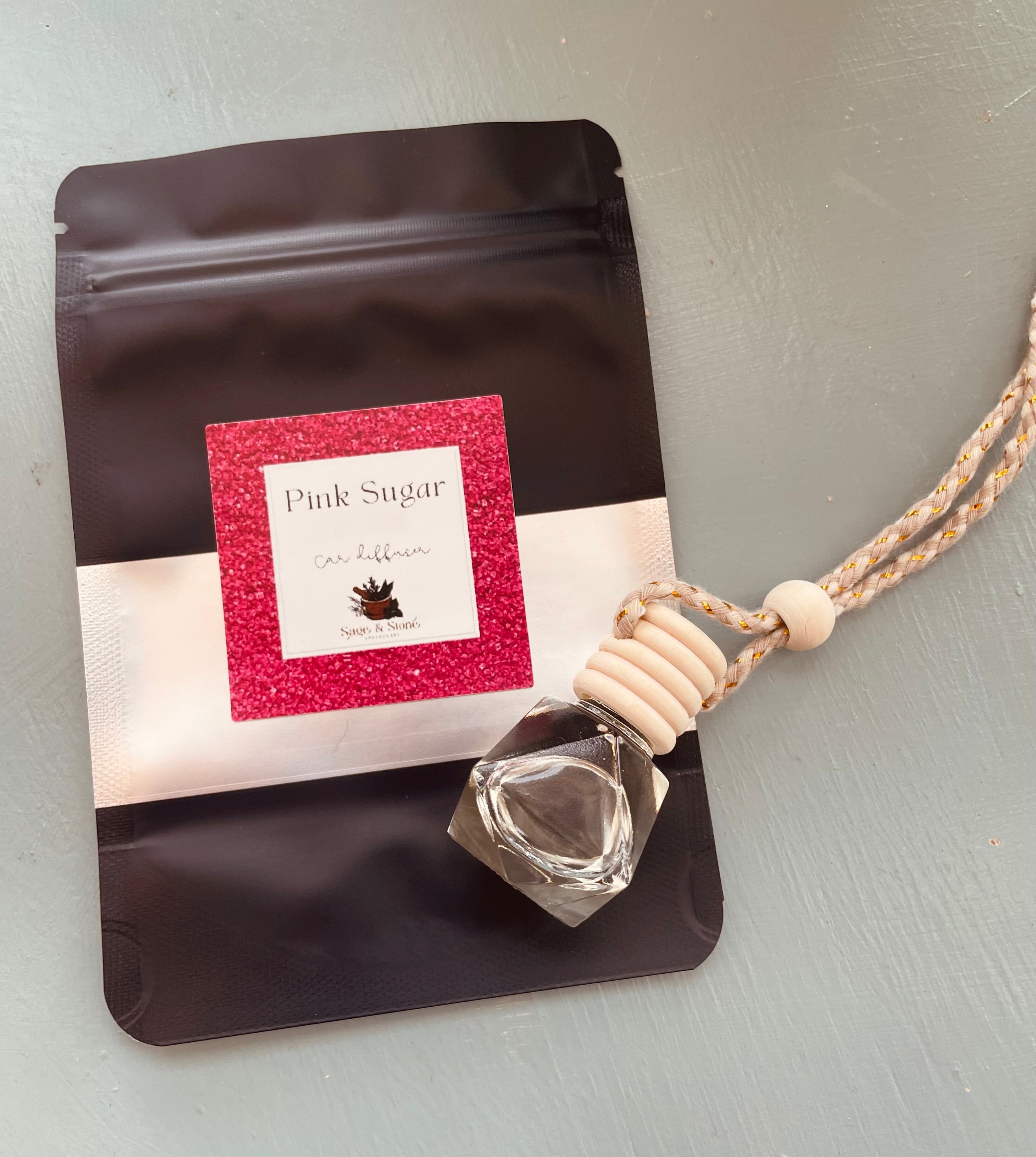Pink Sugar Car Diffuser by Sage & Stone Apothecary with pink decorative accents and a sleek design for adding fragrance to your vehicle.